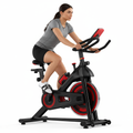 Woman using Pulserig indoor exercise bike in a home workout setting white background